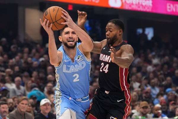 Cleveland Cavaliers guard Ty Jerome (2) drives past Miami Heat forward Haywood Highsmith (24) in the first half of an NBA basketball game Wednesday, March 5, 2025, in Cleveland. (AP Photo/Sue Ogrocki)