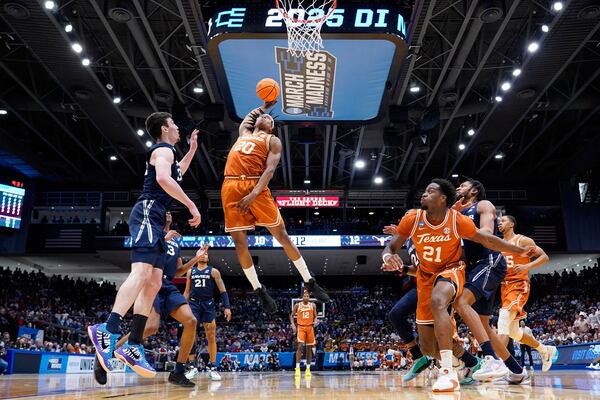 Texas guard Tre Johnson (20) dunks against Xavier forward Zach Freemantle (32) during the first half of a First Four college basketball game in the NCAA Tournament, Wednesday, March 19, 2025, in Dayton, Ohio. (AP Photo/Jeff Dean)