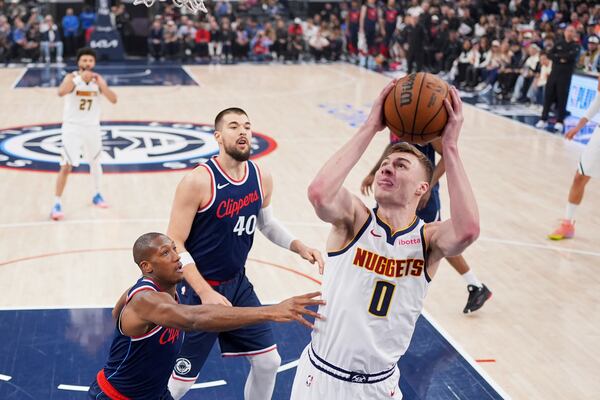 Denver Nuggets guard Christian Braun, right, shoots as Los Angeles Clippers guard Kris Dunn, left, and center Ivica Zubac defend during the first half in Game 6 of an NBA basketball first-round playoff series Thursday, May 1, 2025, in Inglewood, Calif. (AP Photo/Mark J. Terrill)