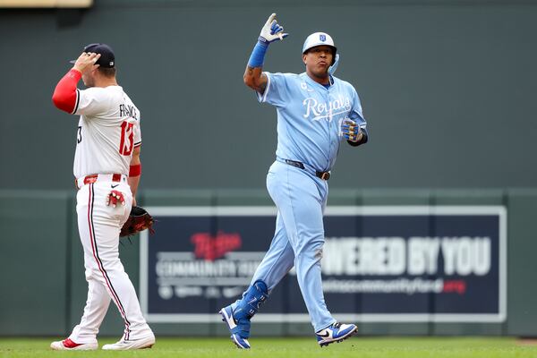 Kansas City Royals designated hitter Salvador Perez, right, celebrates his RBI single against the Minnesota Twins during the fifth inning of baseball game Saturday, May 24, 2025, in Minneapolis. (AP Photo/Matt Krohn)