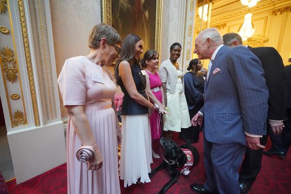 Britain's King Charles III greets Vicky Pattison during a reception in Buckingham Palace, London, in celebration of community-based initiatives raising awareness about cancer and supporting those living with cancer, Wednesday April 30, 2025. (Yui Mok/Pool Photo via AP)