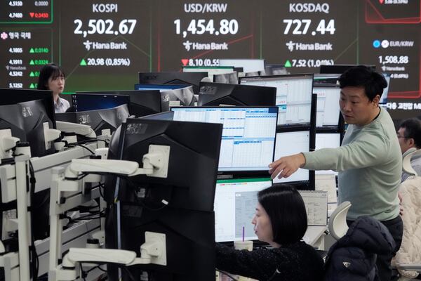 Currency traders watch monitors near a screen showing the Korea Composite Stock Price Index (KOSPI), top left, and the foreign exchange rate between U.S. dollar and South Korean won, top center, at the foreign exchange dealing room of the KEB Hana Bank headquarters in Seoul, South Korea, Wednesday, Feb. 5, 2025. (AP Photo/Ahn Young-joon)