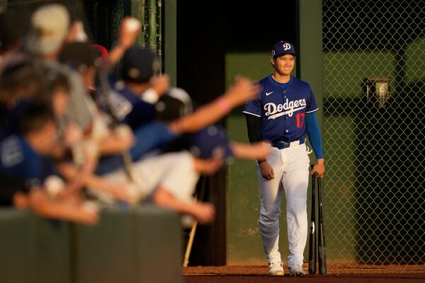 Los Angeles Dodgers designated hitter Shohei Ohtani enters the field before a spring training baseball game against the Los Angeles Angels, Friday, Feb. 28, 2025, in Phoenix. (AP Photo/Ashley Landis)