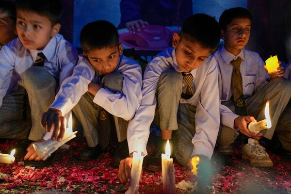 Students place candles during a candle light vigil for children killed in the Indian missile strikes, in Islamabad, Pakistan Thursday, May 8, 2025. (AP Photo/Anjum Naveed)