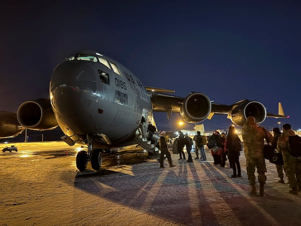 Participants in the Operation Santa program board an Alaska Air National Guard C-17 Globemaster III at Joint Base Elmendorf-Richardson, Alaska, to deliver Santa and Mrs. Claus to Yakutat, Alaska, Wednesday, Dec. 18, 2024. (AP Photo/Mark Thiessen).