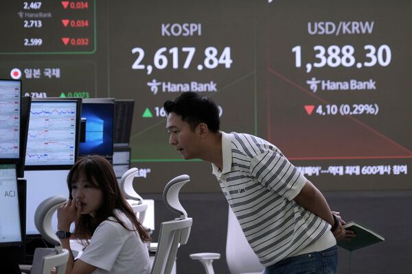 Currency traders watch monitors near a screen showing the Korea Composite Stock Price Index (KOSPI) and the foreign exchange rate between U.S. dollar and South Korean won, top right, at the foreign exchange dealing room of the KEB Hana Bank headquarters in Seoul, South Korea, Wednesday, May 21, 2025. (AP Photo/Ahn Young-joon)