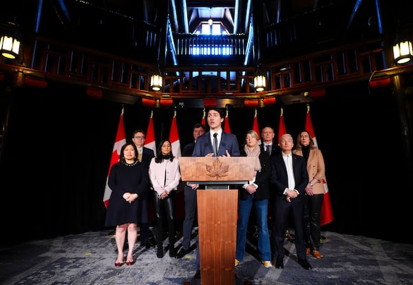 Canadian Prime Minister Justin Trudeau stands with, back left to right, Export Promotion, International Trade and Economic Development Minister Mary Ng, Energy and Natural Resources Minister Jonathan Wilkinson, President of the Treasury Board Anita Anand, Minister of Finance Dominic LeBlanc, Minister of Foreign Affairs Melanie Joly, Minister of Public Safety David McGuinty, Innovation, Science and Industry Minister Francois-Philippe Champagne and Canada's Ambassador to the US Kirsten Hillman as he holds a press conference during a cabinet retreat at Chateau Montebello in Montebello, Tuesday, Jan. 21, 2025. (Sean Kilpatrick/The Canadian Press via AP)