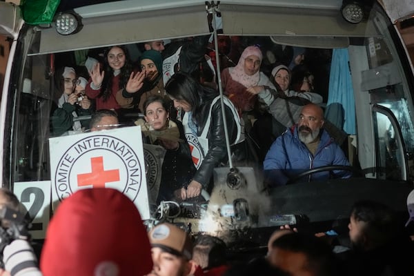 Palestinian female prisoners wave from inside a bus as they arrive in the West Bank city of Beitunia, early Monday, Jan. 20, 2025. (AP Photo/Leo Correa)