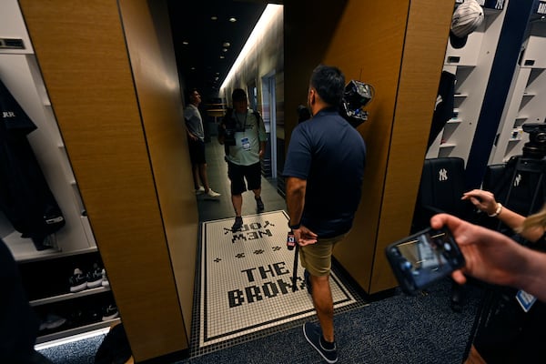 Members of the media walk through a hallway connecting the showers and the New York Yankees clubhouse during a tour of the upgraded team spring training facilities Thursday, Feb. 13, 2025, at George M. Steinbrenner Field in Tampa, Fla. (AP Photo/Steve Nesius)