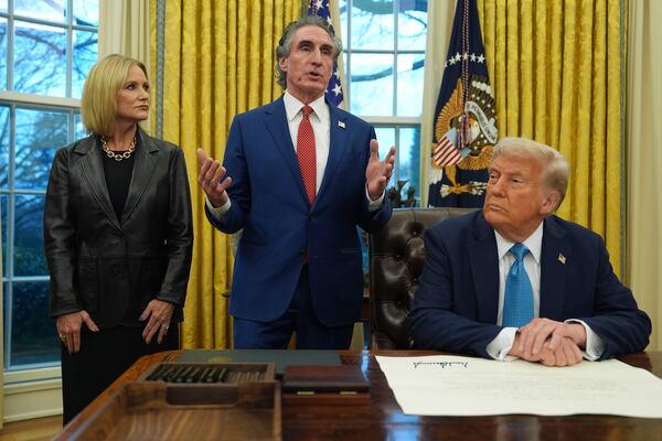 FILE - Interior Secretary Doug Burgum speaks as his wife Kathryn and President Donald Trump listen, in the Oval Office of the White House, Friday, Jan. 31, 2025, in Washington. (AP Photo/Evan Vucci, File)