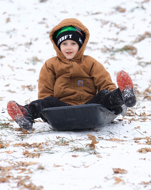 Taking advantage of the lingering ice and snow from the recent winter weather event, Dawson Mauro, 6, races down a steep hill behind Chautauqua Park while sledding, Wednesday, Jan. 8, 2025, in Owensboro, Ky. (Greg Eans/The Messenger-Inquirer via AP)