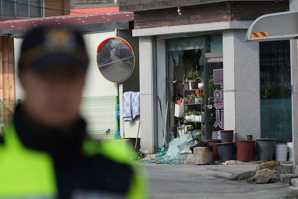 A police officer controls damaged area near the site of an accidental bombing in Pocheon, South Korea, Thursday, March 6, 2025. (AP Photo/Lee Jin-man)