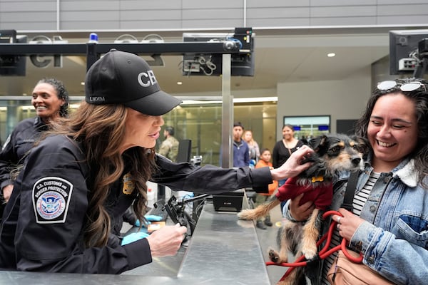 Homeland Security Secretary Kristi Noem, left, greets Jessica Medina and her dog Luna during a tour of the San Ysidro Port of Entry, Sunday, March 16, 2025, in San Diego. (AP Photo/Alex Brandon)