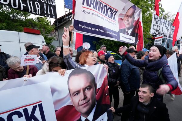 People carry placards in support of conservative presidential candidate Karol Nawrocki in Warsaw, Poland, Tuesday, May 13, 2025. (AP Photo/Czarek Sokolowski)
