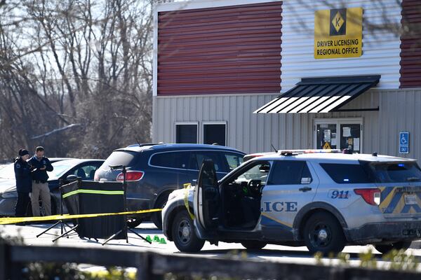 Detectives with the Louisville Metro Crime Scene unit examines a scene of a deadly shooting outside a motor vehicle office in Louisville, Ky., Friday, Feb. 21, 2025. (AP Photo/Timothy D. Easley)