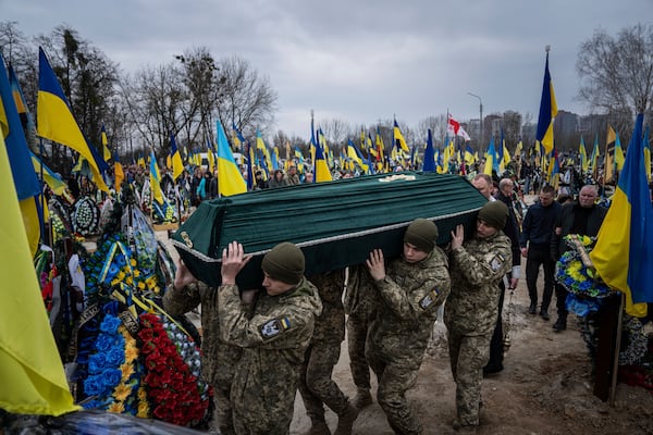 FILE - Ukrainian troops carry the coffin of Andrii Neshodovskiy during his funeral at a cemetery in Kyiv, Ukraine, March 25, 2023. (AP Photo/Evgeniy Maloletka, File)