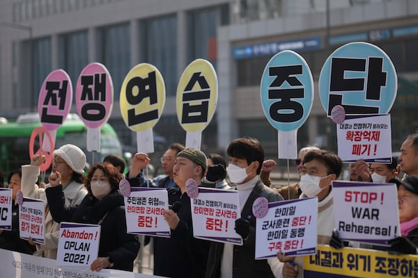 Protesters shout slogans during a press conference demanding to stop the upcoming Freedom Shield military exercise between the U.S. and South Korea, near the Defense Ministry in Seoul, South Korea, Monday, March 10, 2025. The letters read "Stop, War exercise." (AP Photo/Lee Jin-man)