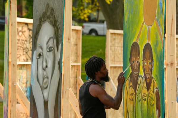 Flahn Manly works on a painting in a park near George Floyd Square on the five-year anniversary of Floyd's death, Sunday, May 25, 2025, in Minneapolis. (AP Photo/Abbie Parr)