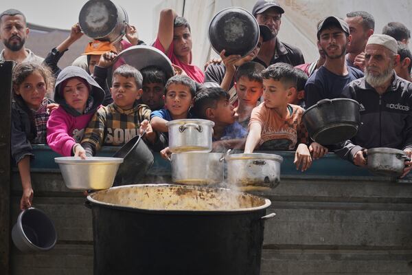 Palestinians wait to get food at a community kitchen in Khan Younis, in southern Gaza Strip, Thursday April 24, 2025.(AP Photo/Abdel Kareem Hana)