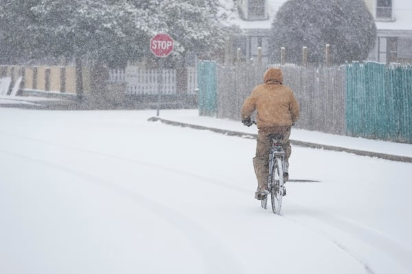 Jesse Thompson rides his bicycle in the snow Friday, Jan 10, 2025, in Nashville, Tenn. (AP Photo/George Walker IV)