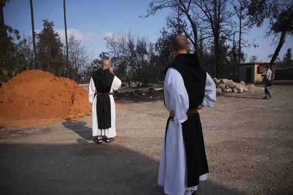 Roman Catholic Trappist monks take in the scene near a wildfire in Latrun, Israel, outside of Jerusalem Thursday, May 1, 2025. (AP Photo/Ohad Zwigenberg)