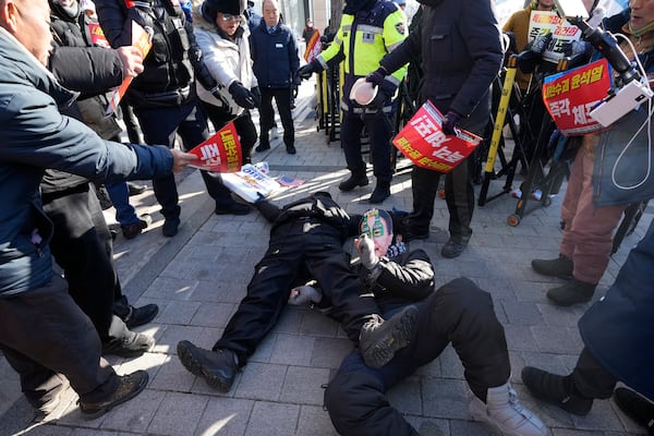 Demonstrators supporting, bottom left, and opposing impeached South Korean President Yoon Suk Yeol lie down on the ground near the presidential residence in Seoul, South Korea, Friday, Jan. 10, 2025. (AP Photo/Ahn Young-joon)