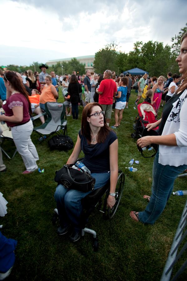 FILE - Anne Marie Hochhalter, center, attends a vigil, July 22, 2012, held for victims of the movie theatre mass shooting that occurred July 20, 2012, in Aurora, Colo. (AP Photo/Barry Gutierrez, File)