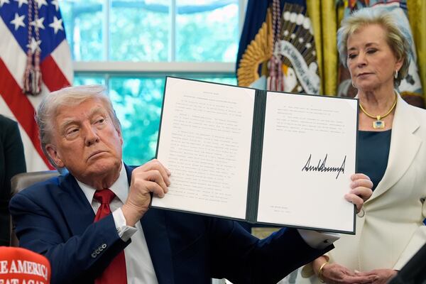 FILE - President Donald Trump holds a signed an executive order relating to school discipline policies as Education Secretary Linda McMahon listens in the Oval Office of the White House, April 23, 2025, in Washington. (AP Photo/Alex Brandon, file)