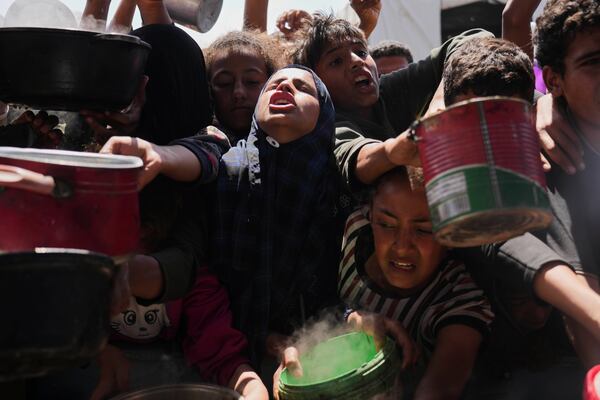 Palestinians struggle to get donated food at a community kitchen in Khan Younis, Gaza Strip, Monday, May 5, 2025. (AP Photo/Abdel Kareem Hana)