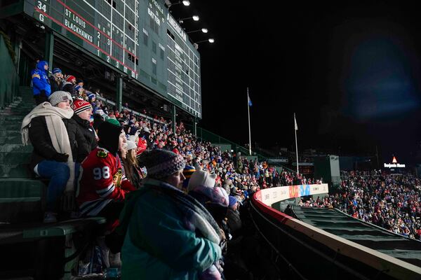 Fans watch the third period of the NHL Winter Classic outdoor hockey game featuring the Chicago Blackhawks and the St. Louis Blues from the bleachers at Wrigley Field, Tuesday, Dec. 31, 2024, in Chicago. (AP Photo/Erin Hooley)