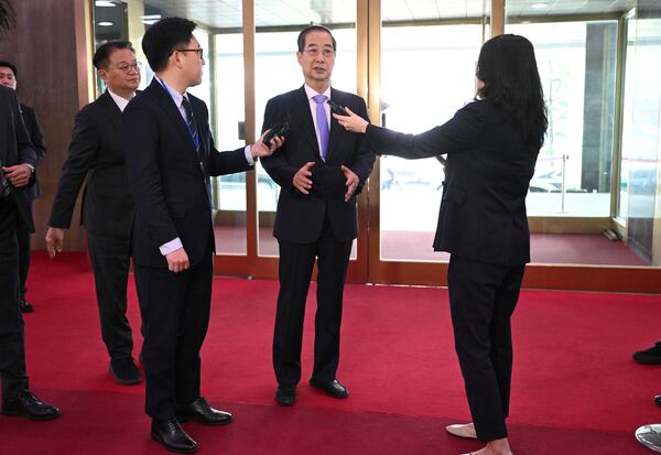 South Korean Prime Minister Han Duck-soo, center, speaks to the media as he arrives at the Government Complex in Seoul Monday, March 24, 2025, after the Constitutional Court dismissed the impeachment of the prime minister. (Jung Yeon-je/Pool Photo via AP)