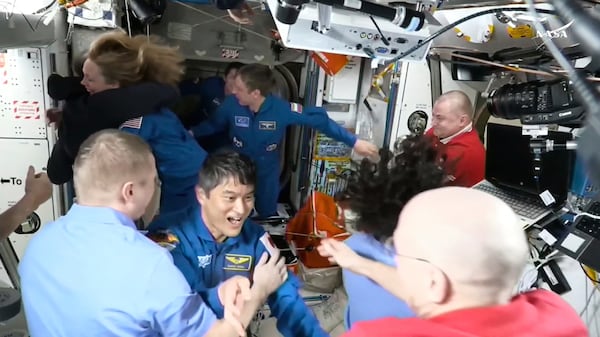 This image made from video by NASA shows astronauts, including Takuya Onishi, center, greeting each other after the SpaceX capsule docked with the International Space Station, Sunday, March 16, 2025. (NASA via AP)