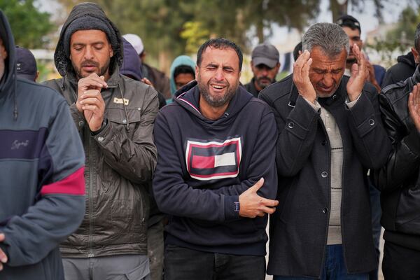 A Palestinian man weeps as he prays during a mass burial ceremony for victims of Israeli army strikes in Khan Younis, southern Gaza Strip, Thursday, March 20, 2025. (AP Photo/Abdel Kareem Hana)