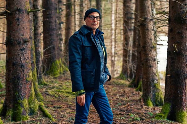 This image released by National Geographic shows Stanley Tucci posing in the woods in the Trentino-Alto Adige in northern Italy, during the filming of his series "Tucci in Italy." (National Geographic via AP)