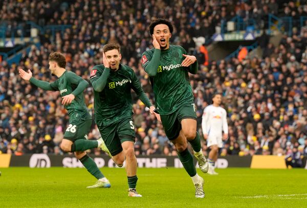 Millwall's Femi Azeez, right, celebrates after scoring his sides second goal during the English FA Cup fourth round soccer match against Leeds United at Elland Road, Leeds, England, Saturday, Feb. 8, 2025. (Danny Lawson/PA via AP)