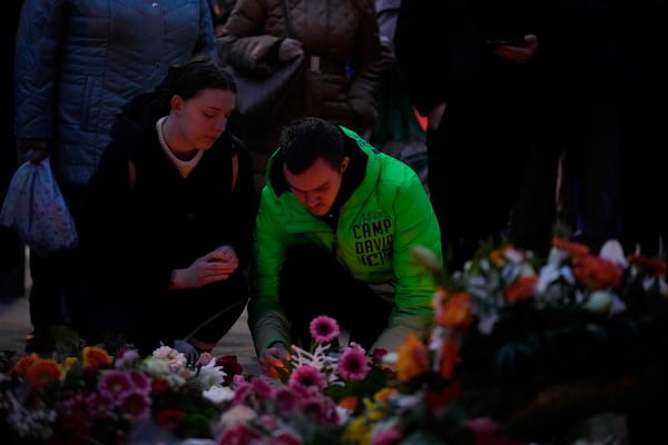 Citizens pay tribute for deaths outside St. John's Church near a Christmas Market, where a car drove into a crowd on Friday evening, in Magdeburg, Germany, Saturday, Dec. 21, 2024. (AP Photo/Ebrahim Noorozi)