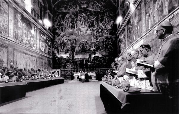 FILE - Cardinals stand in prayer inside the Sistine Chapel after they entered the conclave area for electing the successor of late John Paul I. In the background on the wall Michelangelo's famous fresco "The Last Judgement", in this Oct. 14, 1978 file photo. (AP Photo/Pool, File)