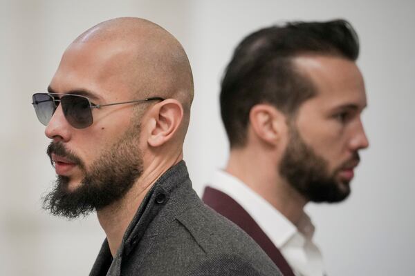 FILE - Andrew Tate, left, and his brother Tristan, right, wait inside the Court of Appeals building in Bucharest, Romania, Tuesday, Jan. 30, 2024. (AP Photo/Vadim Ghirda, File)