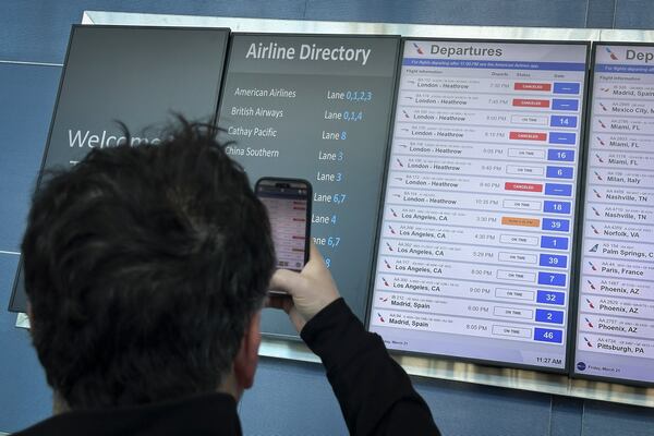 Cancellations for British Airways flights to London Heathrow airport are displayed as cancelled on a departures board at JFK International airport, Friday, March 21, 2025, in New York. (AP Photo/John Minchillo)