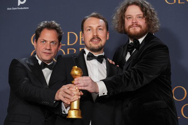 Ron Dyens, from left, Gints Zilbalodis, and Matiss Kaza pose in the press room with the award for best motion picture - animated for "Flow" during the 82nd Golden Globes on Sunday, Jan. 5, 2025, at the Beverly Hilton in Beverly Hills, Calif. (AP Photo/Chris Pizzello)