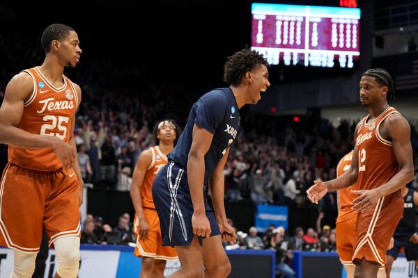 Xavier guard Dailyn Swain, center, reacts after scoring as Texas players look on during the second half of a First Four college basketball game in the NCAA Tournament, Wednesday, March 19, 2025, in Dayton, Ohio. (AP Photo/Jeff Dean)