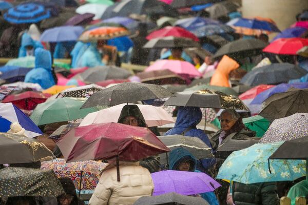 Participants in a mass for the jubilar pilgrims from Naples wait for the start of the celebration under pouring rain in St. Peter's Square at The Vatican, Saturday, March 22, 2025. (AP Photo/Andrew Medichini)