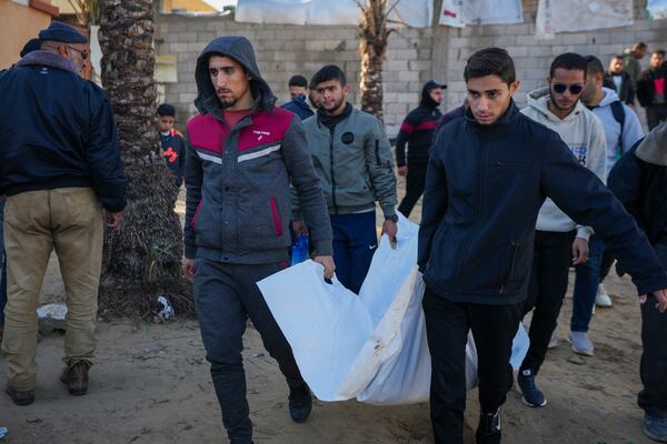 A body is carried to the area outside the hospital after an Israeli army strike early Thursday morning in the Muwasi area, in Khan Younis in the central Gaza Strip, Thursday Jan. 2, 2025. According to Palestinian medical officials, the airstrike killed at least 10 people, including three children and two senior police officers, in an Israeli-designated humanitarian zone in the Gaza Strip. (AP Photo/Abdel Kareem Hana)