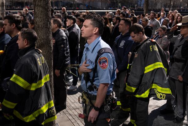 A firefighter listen to the national anthem during a ceremony marking the anniversary of the 1993 World Trade Center bombing at the 9/11 Memorial, Wednesday, Feb. 26, 2025, in New York. (AP Photo/John Minchillo)