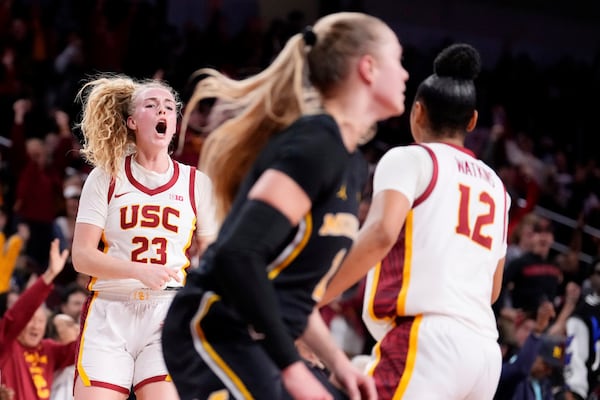 Southern California guard Avery Howell, left, celebrates after scoring with guard JuJu Watkins, right, as Michigan guard Olivia Olson walks away during the second half of an NCAA college basketball game, Sunday, Dec. 29, 2024, in Los Angeles. (AP Photo/Mark J. Terrill)