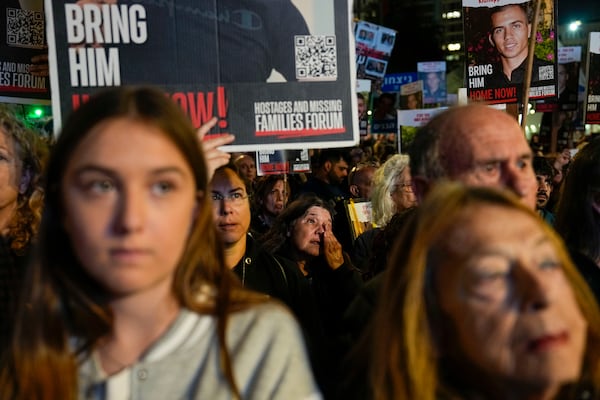 FILE.- Families and supporters of Israeli hostages held by Hamas in Gaza hold their photos and shout slogans during a rally calling for their release, in Tel Aviv, Israel, Saturday, Dec. 30, 2023. (AP Photo/Ariel Schalit, File)