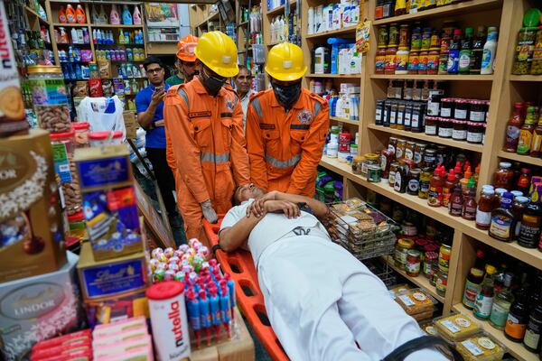 National Disaster Response Force team members carry out a mock drill in a market to train civilians and security personnel to respond in case of attack, in New Delhi, India, Wednesday, May 7, 2025. (AP Photo/Manish Swarup)