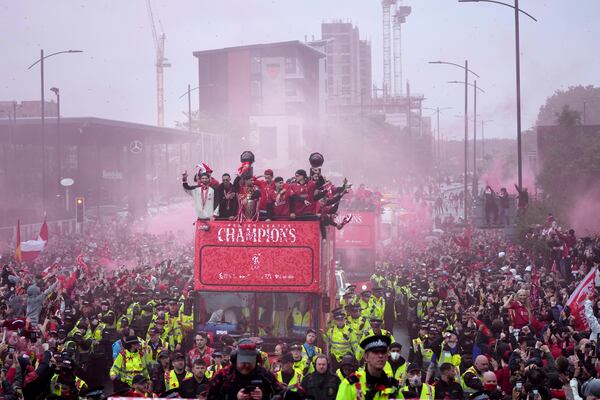 Liverpool players celebrate with the trophy on an open-top bus during the Liverpool FC Premier League victory parade in Liverpool, England, Monday, May 26, 2025.(AP Photo/Jon Super)