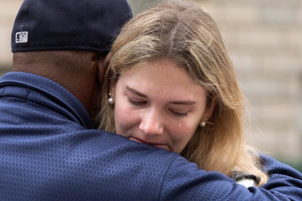 United States Agency for International Development (USAID) worker Juliane Alfen gets a hug from a former USAID worker after retrieving her personal belongings from USAID's headquarters in Washington, Thursday, Feb. 27, 2025. (AP Photo/Manuel Balce Ceneta)