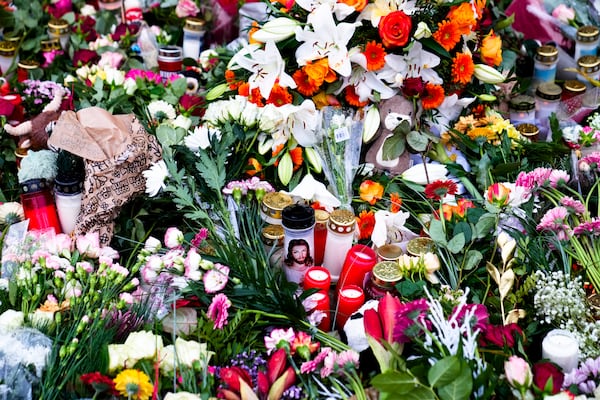 Flowers and candles laid down in front of the Johannis church close to the Christmas market, where a car drove into a crowd on Friday evening, in Magdeburg, Germany, Sunday, Dec. 22, 2024. (AP Photo/Ebrahim Noroozi)